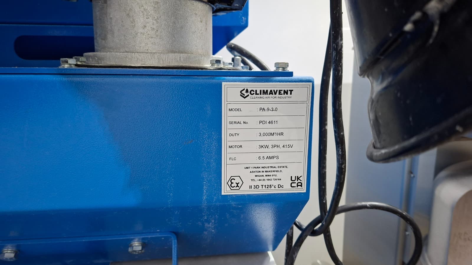 Steel drums and flammable liquid containers in storage, with a drum pump fitted